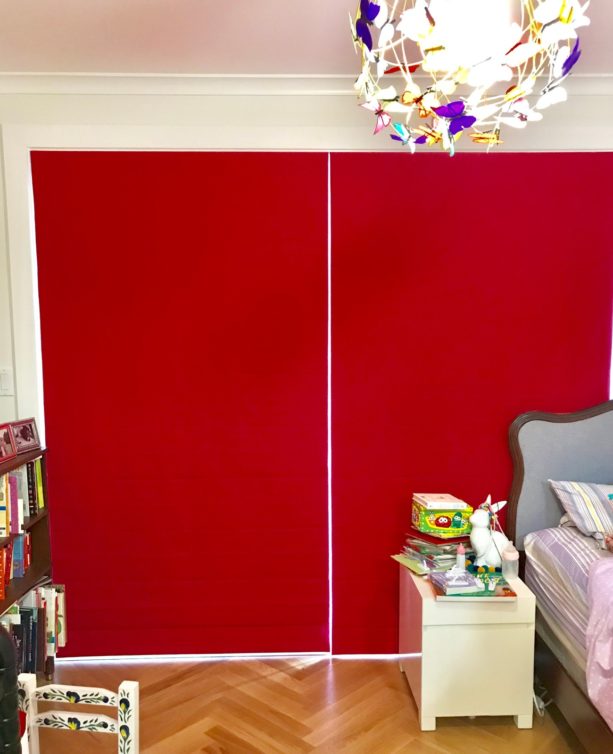 solid crimson red flat roman shade in a modern bedroom