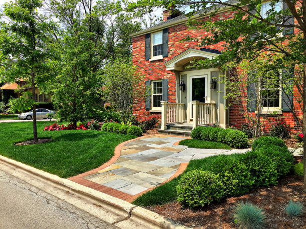 a traditional colonial red brick house with black shutters