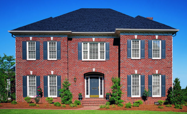 a traditional red brick house with deep blue shutters