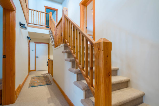 an interior with white doors, stained wood trim, and stair railing with coordinating look