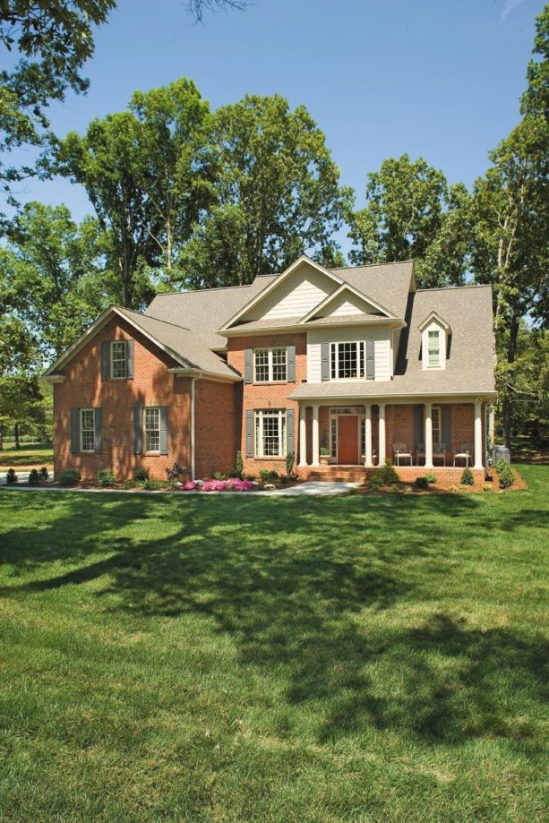 an orange brick house with grey shutters