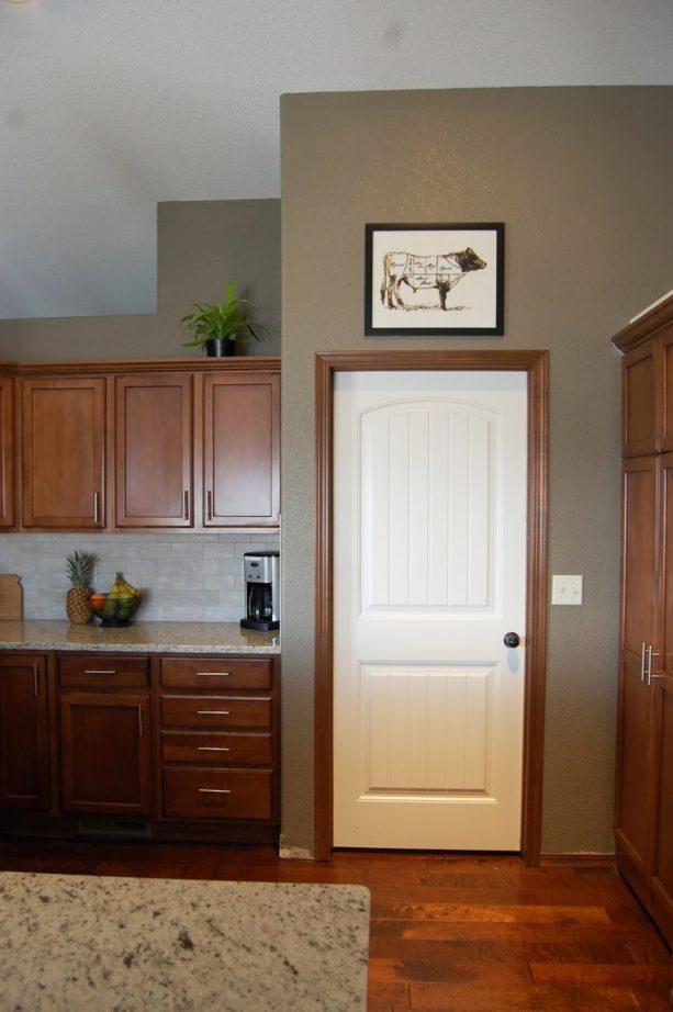 the combination of white door, dark wood trim, and dark wood kitchen furniture