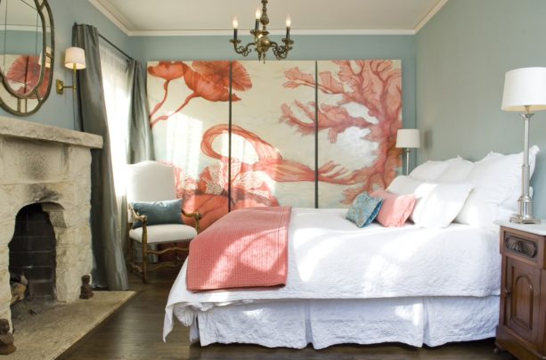 a Mediterranean bedroom with blue domination and an enormous coral color artwork as the focal point