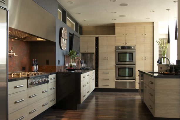 a contemporary kitchen with rift sawn white oak cabinets, stainless steel appliances, and dark grey wall paint