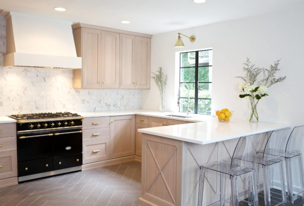 a transitional kitchen with quarter sawn light oak cabinets, light grey wall paint, and black stove