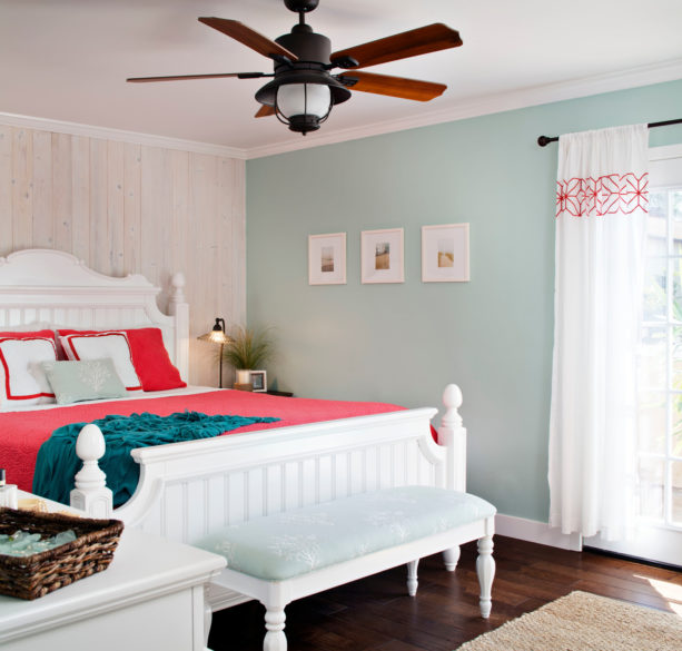 a white bed with coral bedding and ocean blue blanket