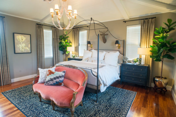 adding a coral tone by placing a sofa in a dark blue and grey bedroom