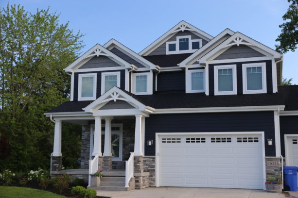 a dark navy craftsman house with white trim