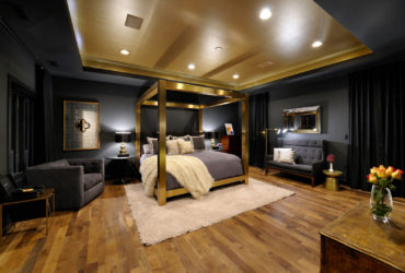 a luxurious eclectic bedroom with black, gold, and grey colors