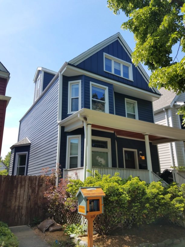 a traditional house with deep ocean blue paint siding and white trim