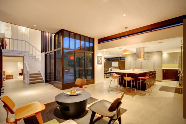 an open-concept mid-century modern kitchen with limestone-like porcelain floor