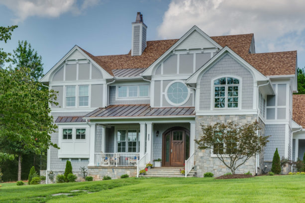 an elegant eclectic traditional light grey house with brown roof