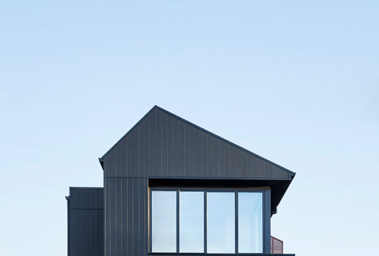 a contemporary house with black siding and red brick