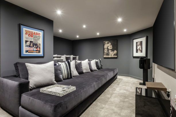 a home theater with dark grey walls and beige carpet floor