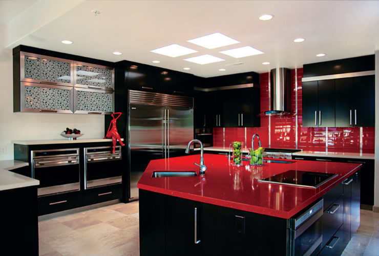 the combination between black cabinets and island with glossy red countertops and tiled backsplash