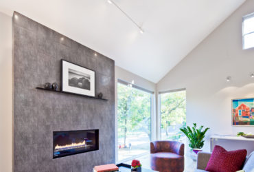 a grey living room with multi-tone red rug under the black coffee table