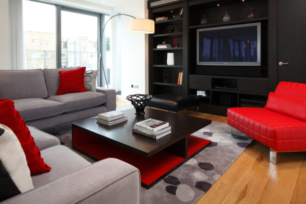 a modern living room with red, black, and grey color scheme