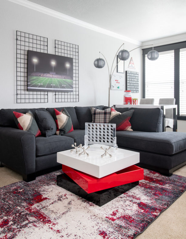 bold living room interior with charcoal grey sectional and red detailing