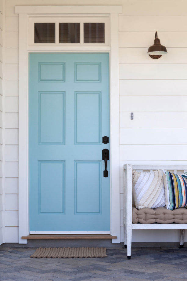 a light blue farmhouse front door with small transom and simple butted trim