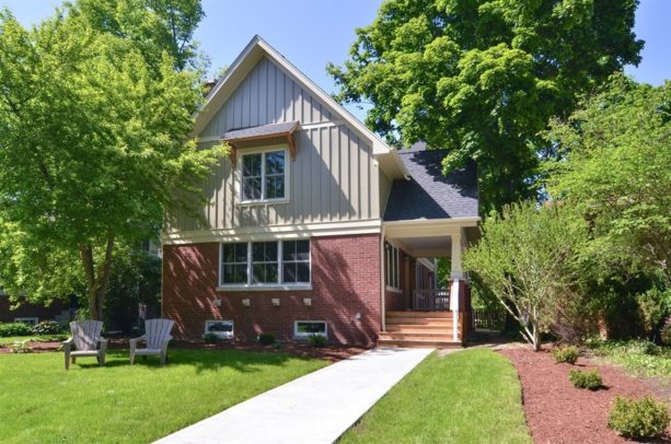 red brick home paired with grey-painted siding on the second floor