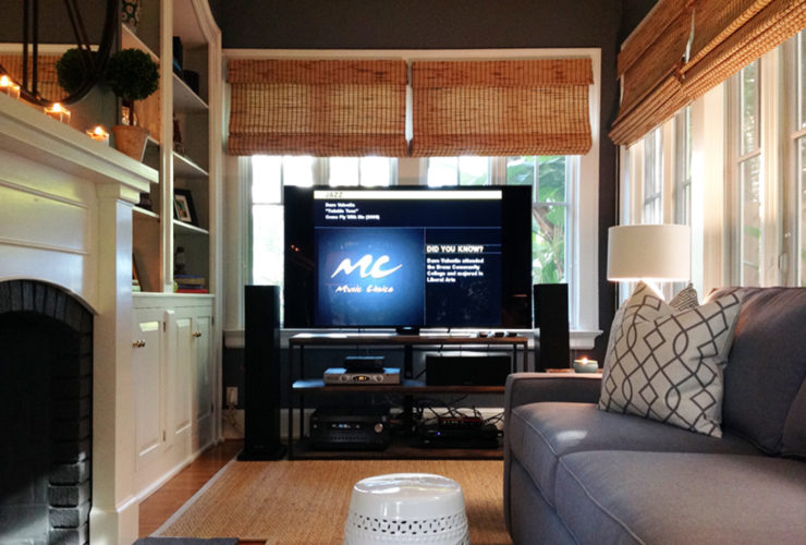 a large TV with complete entertainment equipment in front of the window