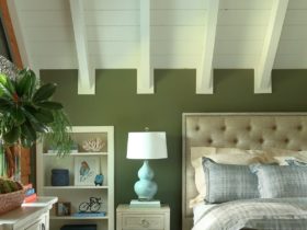 a bed with gray bedding set in a bedroom dominated with green