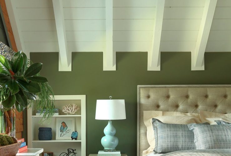 a bed with gray bedding set in a bedroom dominated with green