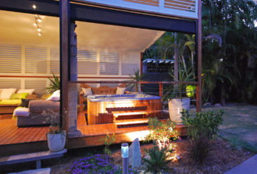 a stylish white custom aluminum shutter for extra privacy for the hot tub on a roofed deck