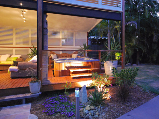 a stylish white custom aluminum shutter for extra privacy for the hot tub on a roofed deck
