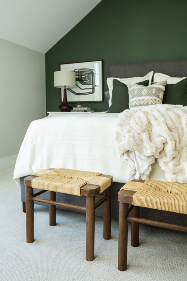 a traditional guest room with ash gray bed and pine green accent wall