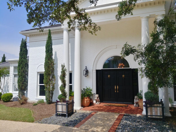 a red brick house painted in white to refresh the look