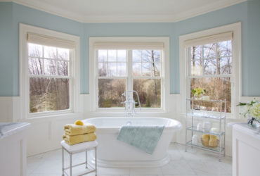 a traditional bathroom with soft blue walls and white tile porcelains to give a relaxing sensation