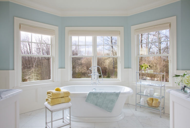 a traditional bathroom with soft blue walls and white tile porcelains to give a relaxing sensation