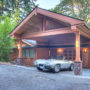 sizeable arts and crafts carport in front of a wooden siding garage