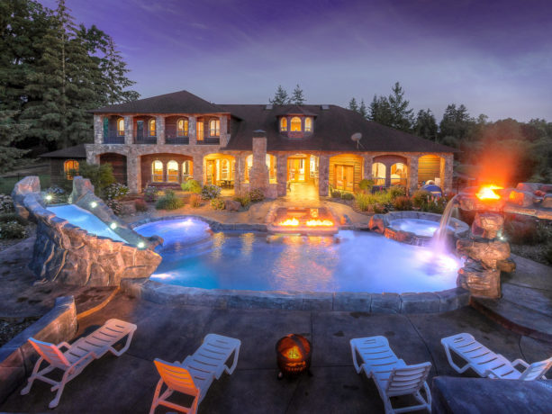 a huge mediterranean styled kidney pool with stamped concrete around