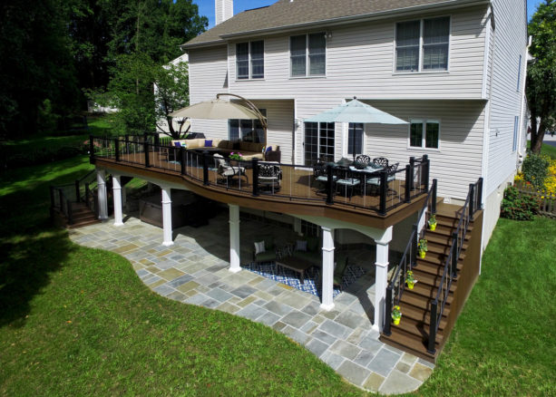 flagstone patio under a dark wood deck idea