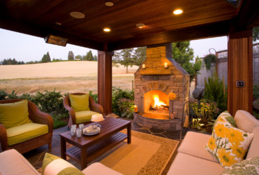 slate carpeted covered patio with fieldstone fireplace