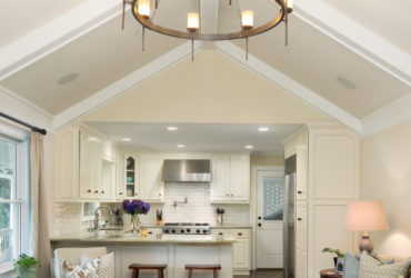 crisp white small peninsula kitchen and classic living room combo