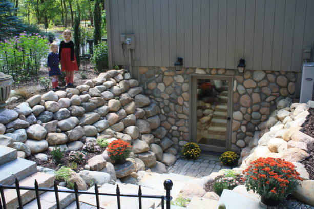 hinged glass door option with a gray frame in a stone walled walkout basement