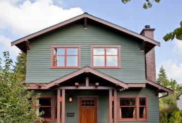 lovely moss green house with wooden nutmeg brown trim