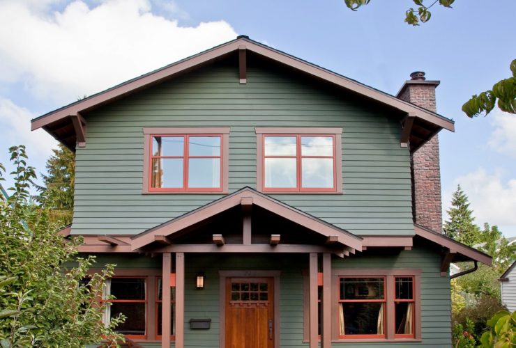 lovely moss green house with wooden nutmeg brown trim