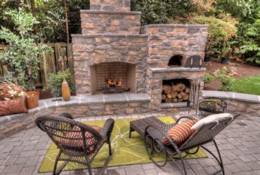 three-tiered outdoor fireplace with a wood-burning pizza oven on its side