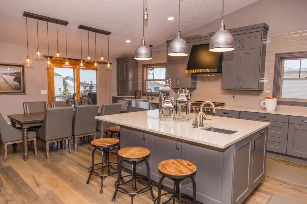 spacious kitchen with gray cabinets, white countertops, and medium tone wood floor