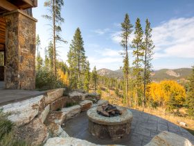 the idea of a rustic-styled patio with a fire pit made of stamped and stained concrete