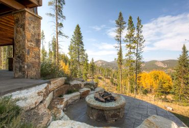 the idea of a rustic-styled patio with a fire pit made of stamped and stained concrete