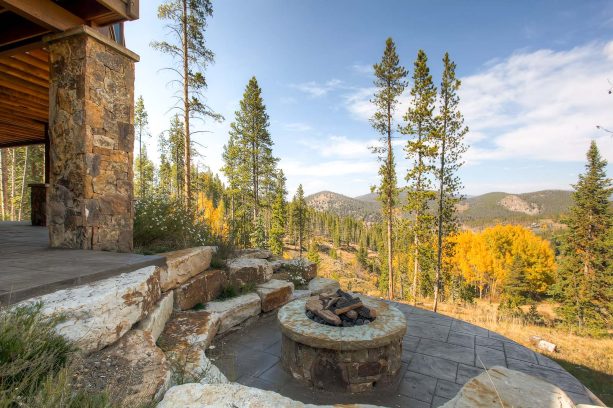 the idea of a rustic-styled patio with a fire pit made of stamped and stained concrete