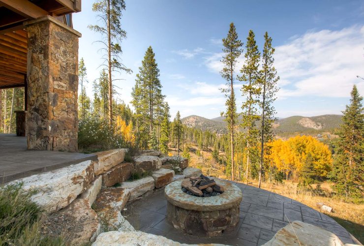 the idea of a rustic-styled patio with a fire pit made of stamped and stained concrete