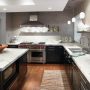 dark kitchen cabinets with light laminate countertops balanced by the gray backsplash
