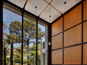 large living room with brown panel wall and black trim completed with window wall