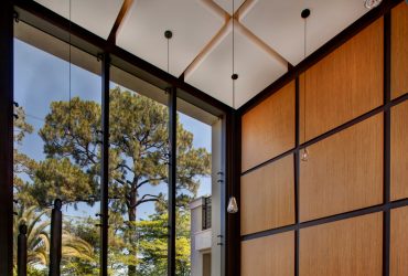large living room with brown panel wall and black trim completed with window wall